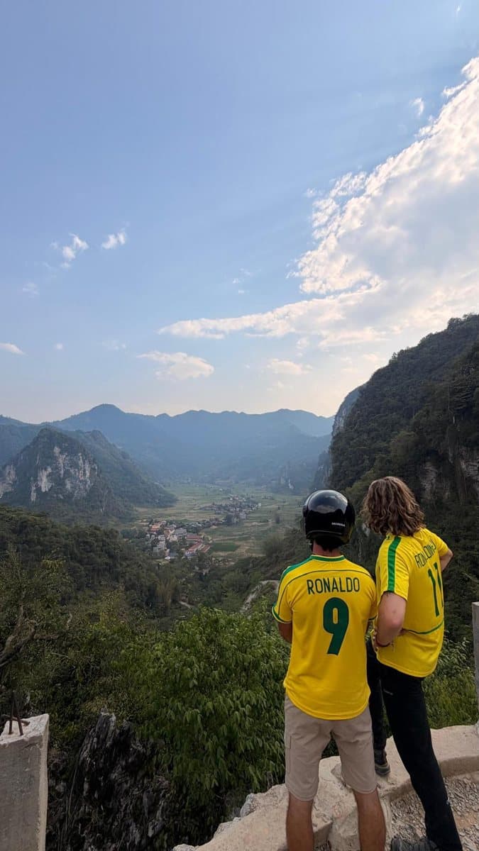 Deux voyageurs en maillots du Brésil face à une vallée