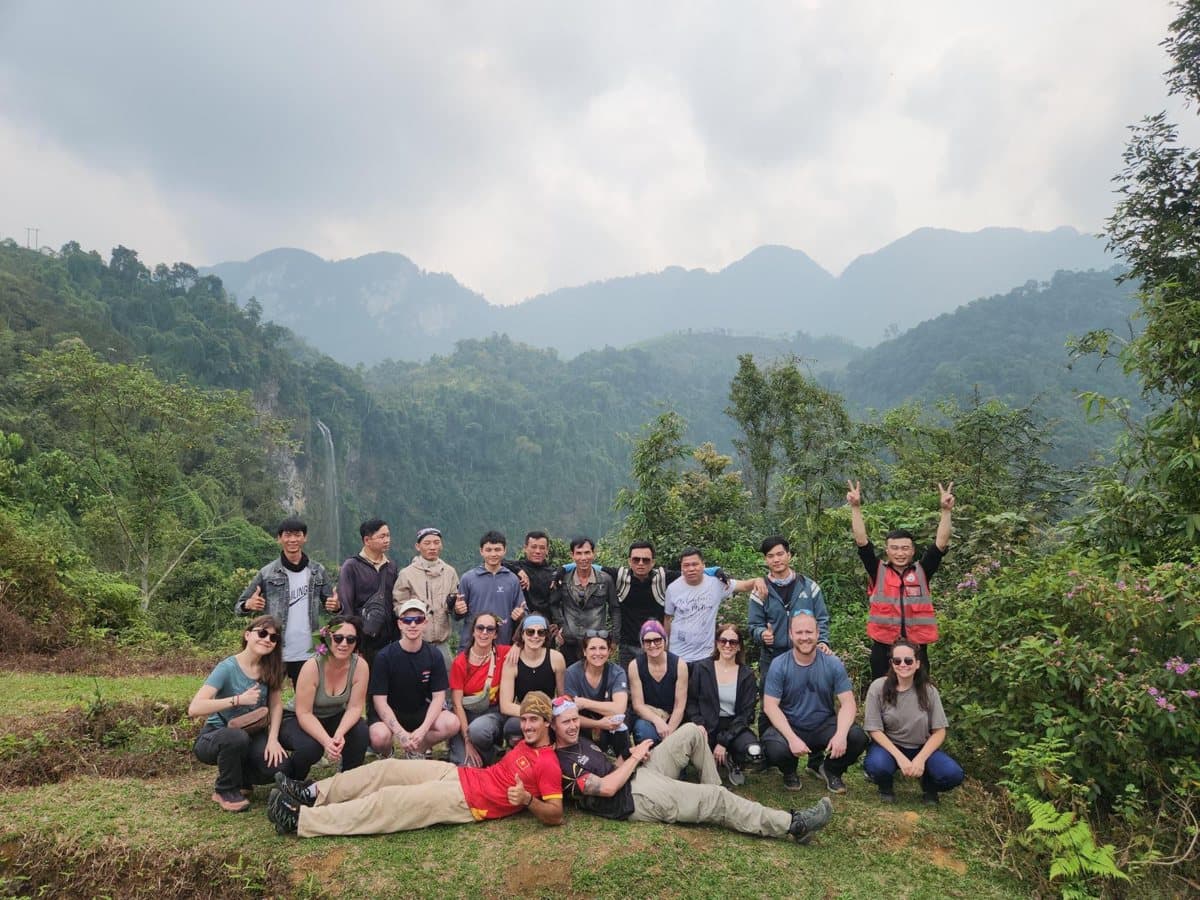 Photo de groupe avec les guides locaux devant une cascade