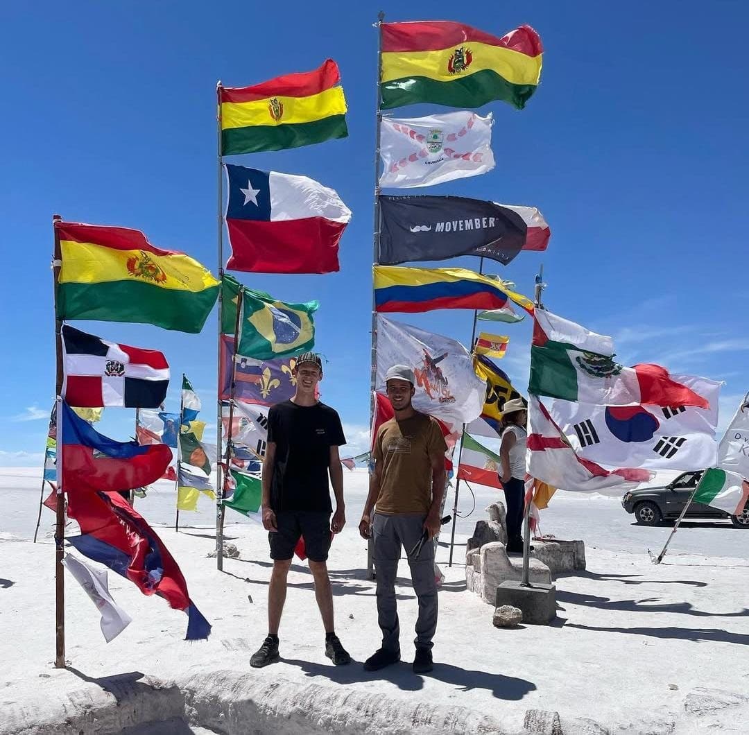 Deux voyageurs au milieu des drapeaux sur le salar