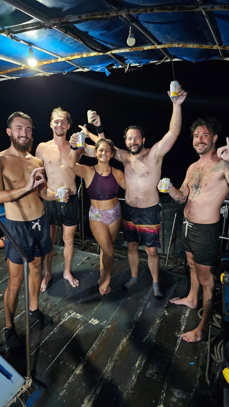 Le groupe trinque sur le pont d’un bateau de nuit