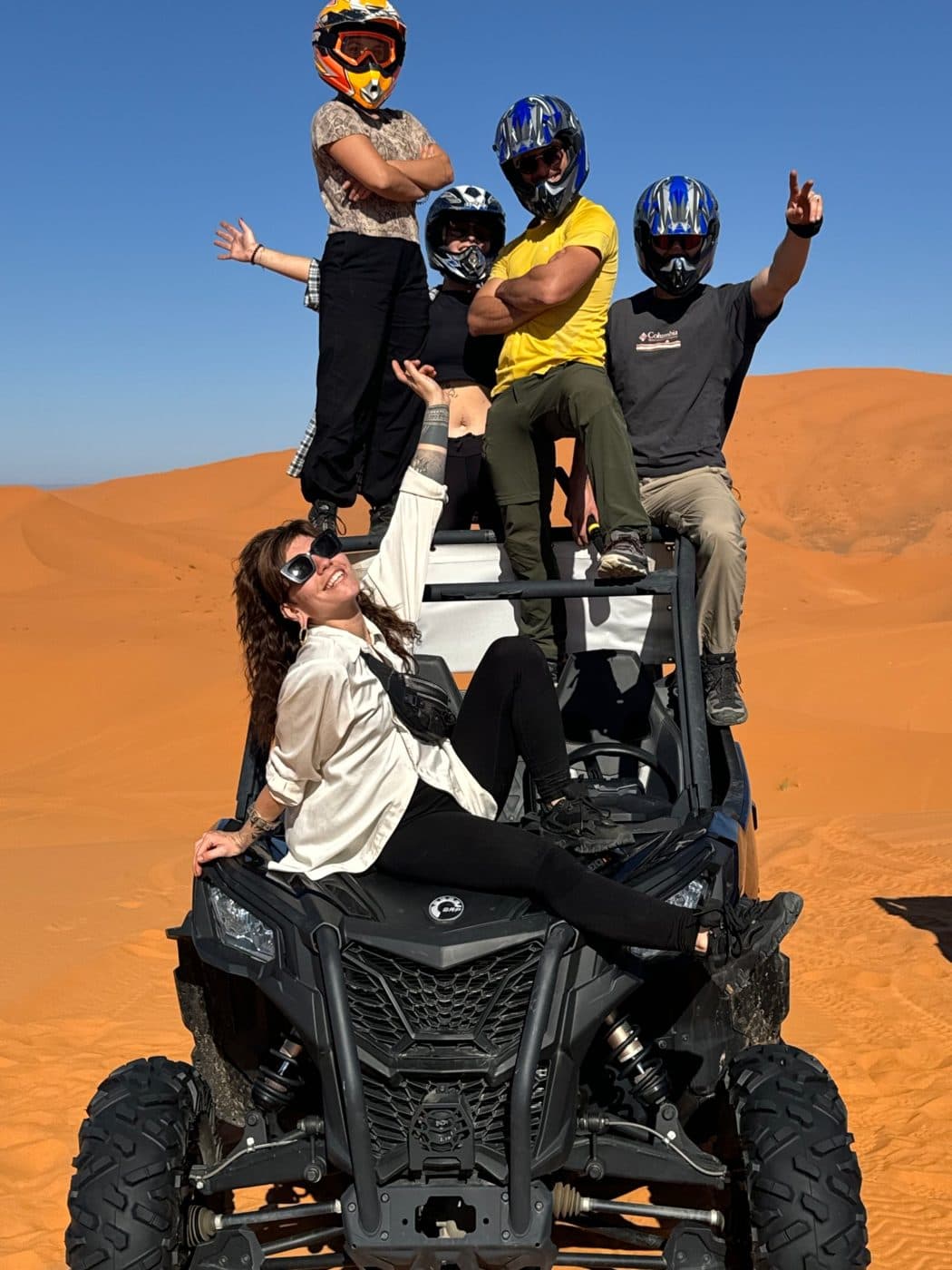 Le groupe casqué sur un buggy dans les dunes orange