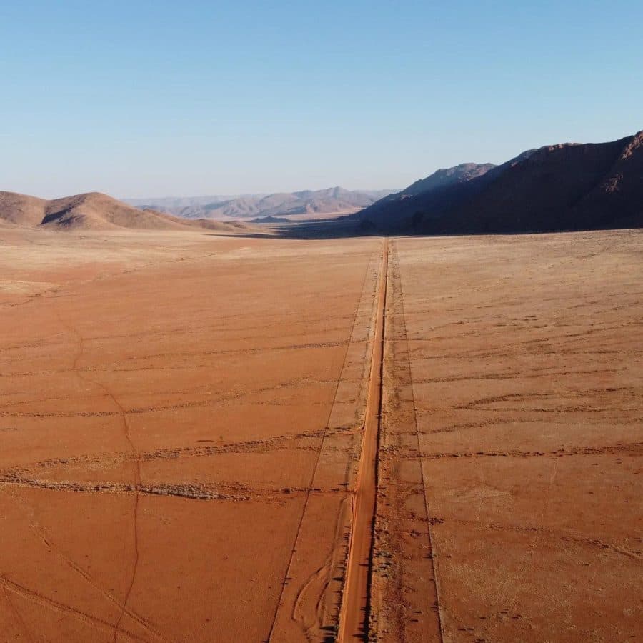 Piste de sable rouge entre deux massifs